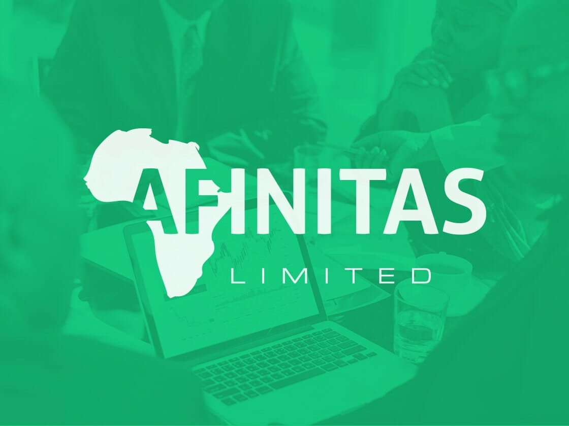 Green-tinted image with the logo "AFINITAS LIMITED" in white, featuring the silhouette of Africa on the left of the text. The background shows blurred figures having a discussion around a table with a laptop displaying graphs and two glasses of water on it.