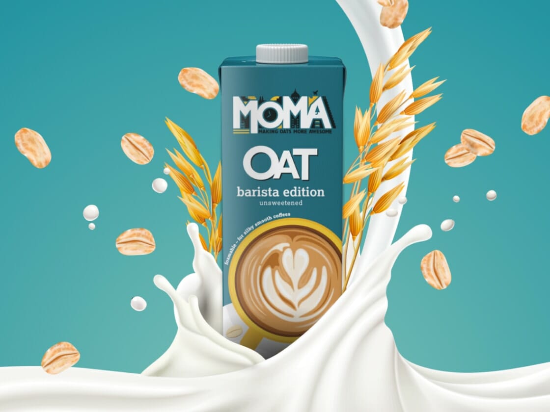 Promotional image of a carton of Moma Milk in barista edition surrounded by a splash of milk, oats, and wheat for the landing page.