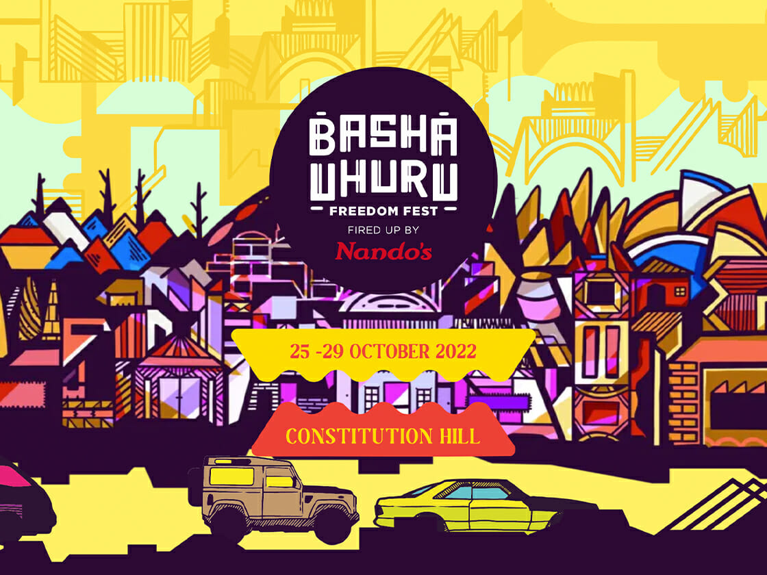 Illustrated promotional graphic for the Basha Uhuru Freedom Fest, showing colourful Johannesburg-inspired buildings, vehicles and skyline shapes with the event dates 25–29 October 2022 and Constitution Hill.
