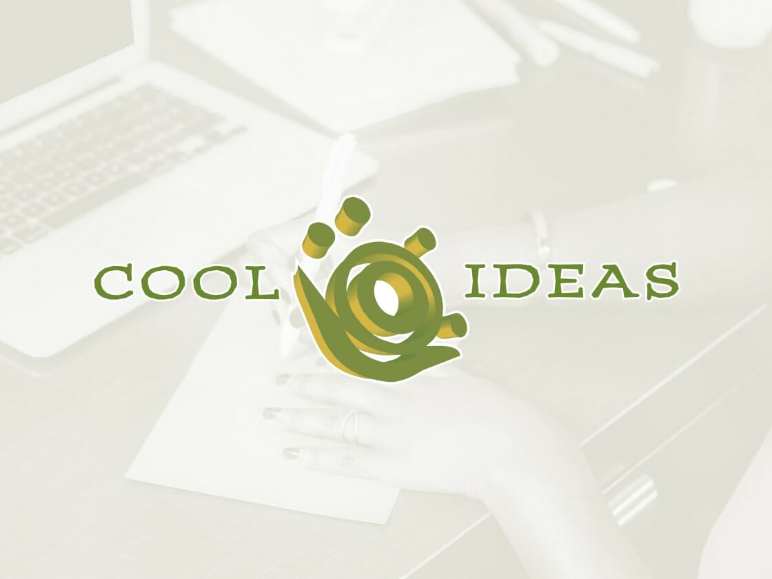 A graphic design featuring the words "COOL IDEAS" in green, with a stylish logo between them resembling a light bulb and abstract design elements in green and yellow. In the background, a blurred image shows a person writing on a sheet of paper on a wooden desk with a laptop nearby.