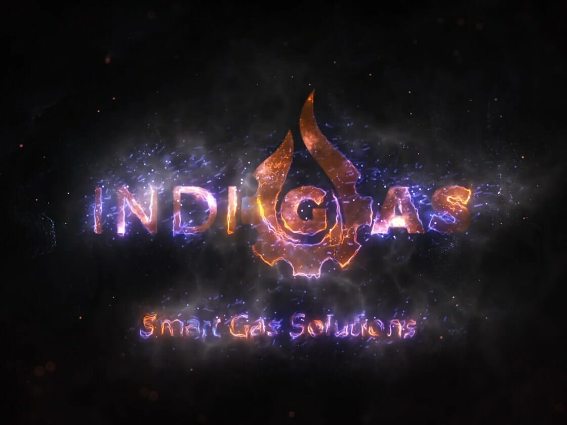 IndiGas logo featuring a bright, orange flame design placed above the company's name. The letters "I" and "G" are integrated into the flame. Below this, the tagline "Smart Gas Solutions" is written in smaller, shimmering text. The background is dark with spark-like effects.