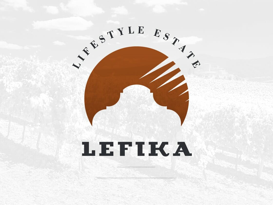 Logo for Lefika Lifestyle Estate. The central design features an arch silhouette in brown with stylized, diagonal lines extending upward. Surrounding the arch, the text reads "LIFESTYLE ESTATE" in an arc at the top and "LEFIKA" in bold black letters at the bottom. Background: faint vineyard image.