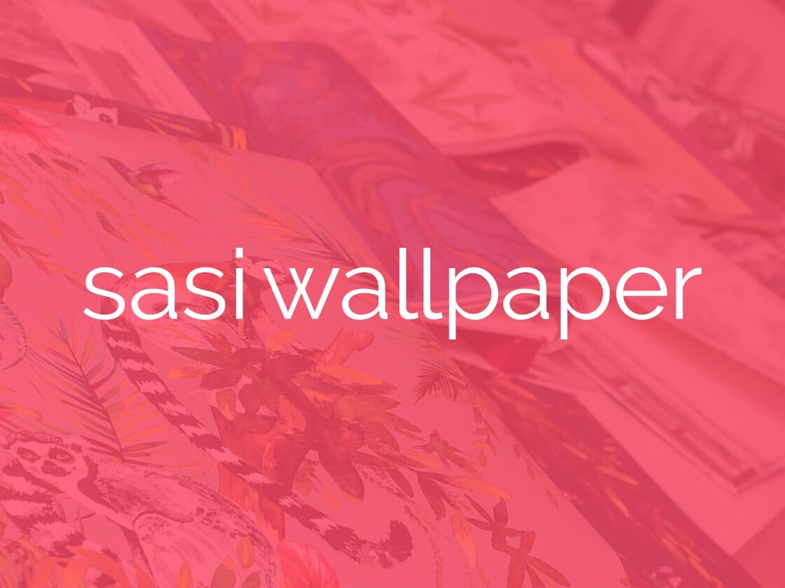 A variety of colorful wallpaper designs are spread out in the background, with a pink overlay dominating the scene. The overlay features the text "sasi wallpaper" in a simple, white, sans-serif font positioned in the center of the image.