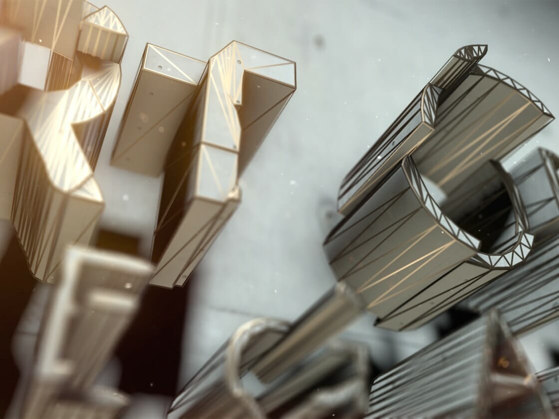 Detailed close-up of three-dimensional, metallic letters floating against a blurred background. The letters have a futuristic, geometric design with illuminated edges and intricate, angular patterns. Light reflections on the metallic surfaces enhance the structures' depth and complexity.