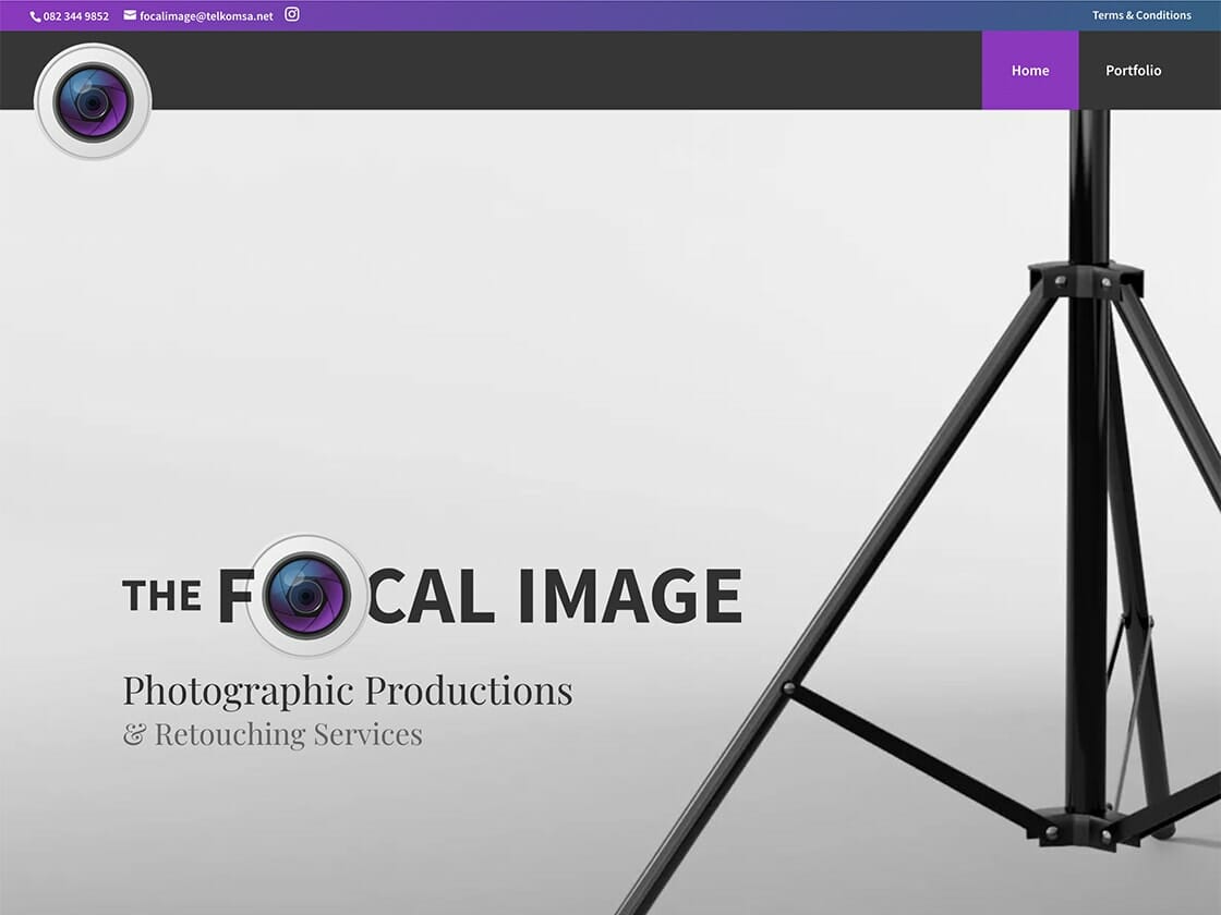 Website homepage for a photography business called "The Focal Image." The header features a contact number, email, and navigation links for "Home" and "Portfolio." At the center, a tripod leg frames the business name alongside a camera lens icon. The tagline reads "Photographic Productions & Retouching Services.