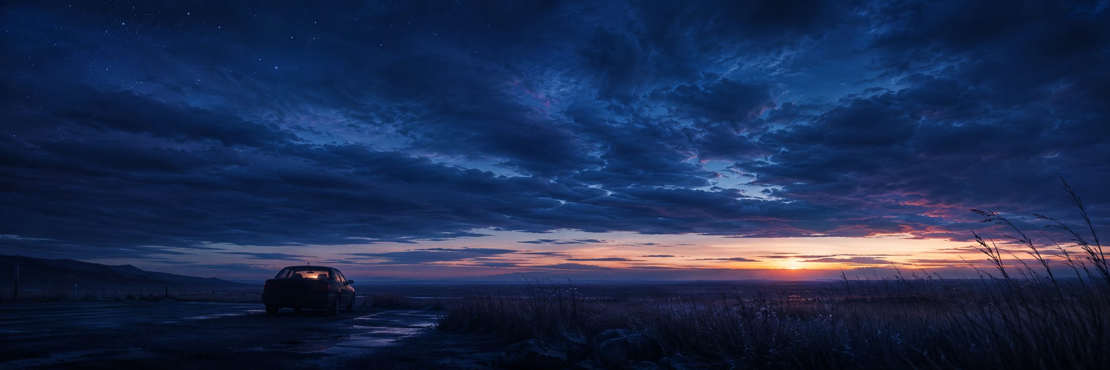 A car parked on a rural road at sunset with dramatic clouds overhead in an open landscape.