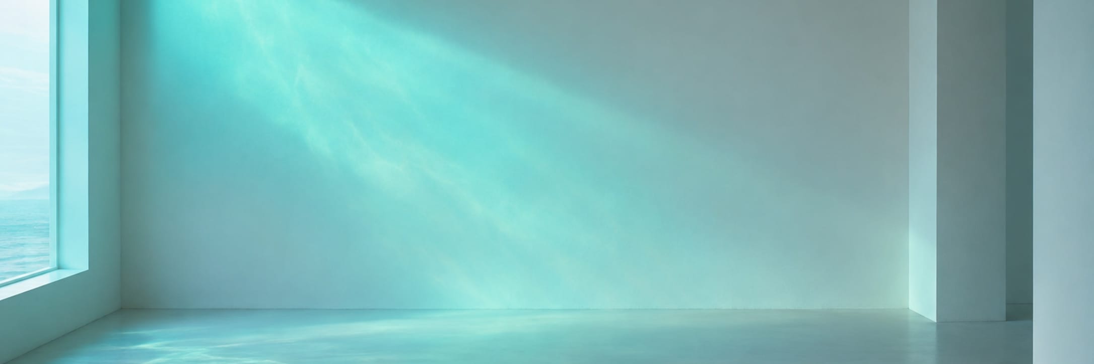A bare room is washed in a soft blue-green band of light.